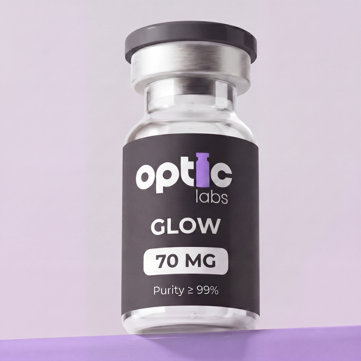 A small glass vial labeled Optic Labs GLOW70 (BPC-157 10mg + GHK-CU 50mg + TB-500 10mg) stands upright against a light purple background. Its black label features white and purple text, similar to other Optic Labs vials. Optic Labs Au